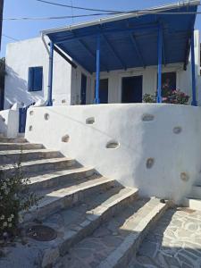 un edificio blanco con escaleras delante en Δίκλινο δωμάτιο Δονούσα με εξαιρετικό μπαλκόνι en Donoussa