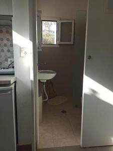 baño con lavabo y aseo y ventana en Δίκλινο δωμάτιο Δονούσα με εξαιρετικό μπαλκόνι en Donoussa