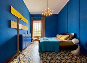 a blue bedroom with a bed and a chandelier at Hostal Bubango in San Andres y Sauces