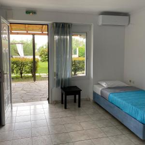 a bedroom with a bed and a door to a patio at Pansion Argo in Nea Moudania