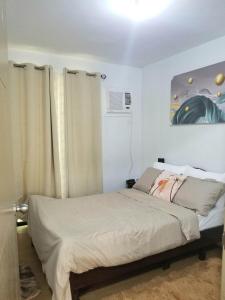 a bedroom with a bed and a painting on the wall at Family Group Affordable Staycation in tagaytay in Tagaytay