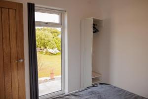 a bedroom with a door open to a window at Ardvreck Chalet self-catering in Kyleakin