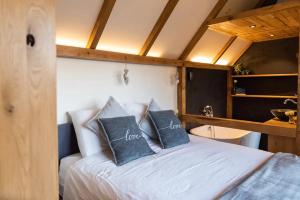 1 dormitorio con 1 cama con 2 almohadas en La vie en Rose - Pet friendly Tiny house in the nature with fenced garden, en Torhout