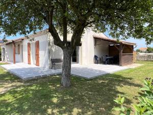 ein weißes Haus mit einem Baum im Hof in der Unterkunft Résidence du Moulin Girard in Jard-sur-Mer + 18 Fotos