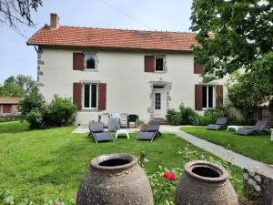 ein großes weißes Haus mit einem Hof mit Stühlen in der Unterkunft Le Cottage de Paul et Angéline in Boismé