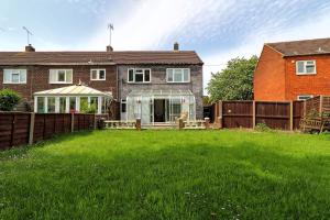 ein Haus mit einem grünen Hof mit einem Gewächshaus in der Unterkunft Elegant 3 Bedroom House in Basildon - Essex Free Parking & Superfast Wifi, upto 6 Guests in Basildon