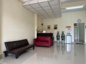 a living room with a couch and a red chair at Thong Sai Homstay BETONG -ทองใสโฮมสเตย์- in Betong