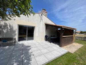 un patio con tavolo e un edificio di Résidence du Moulin Girard a Jard-sur-Mer