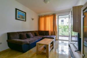 a living room with a couch and a table at Rooms and Apartments Oregon in Budva