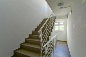 uma escada num quarto com paredes brancas e uma janela em Rooms and Apartments Oregon em Budva