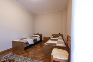 Duas camas num quarto com pisos em madeira em Nonna Elvira Holiday House em Bondone