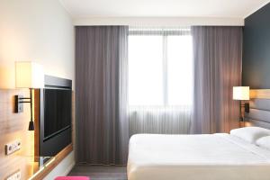 a hotel room with a bed and a large window at Moxy London Excel in London