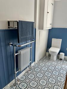 a bathroom with a toilet and a blue wall at Seaside Rooms Gorleston in Gorleston-on-Sea