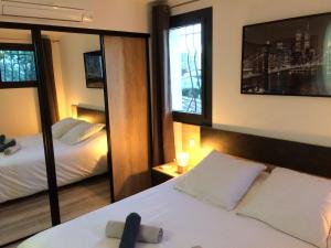 a hotel room with two beds and a mirror at Appart 2 pièces indépendant dans villa proche centre ville au calme in Mandelieu-la-Napoule