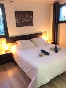 a bedroom with a large white bed with two pillows at Appart 2 pièces indépendant dans villa proche centre ville au calme in Mandelieu-la-Napoule