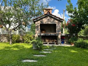 a stone pizza oven in a yard with green grass at Apartment River in Klis