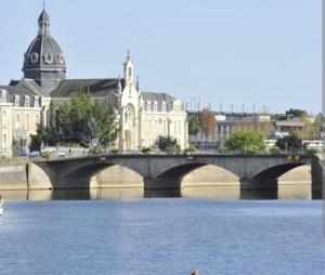 een brug over een rivier in een stad met gebouwen bij Gîte Le Hamo in Saint-Fort