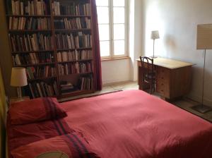 a bedroom with a bed and a desk and book shelves at Chambres d'hôtes au calme 