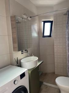ein Badezimmer mit Waschbecken und Waschmaschine in der Unterkunft Sunset view house in Lambiní + 18 Fotos
