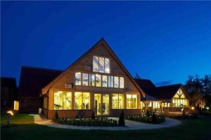 a large wooden house with many windows at night at Lakeside View in Wisbech
