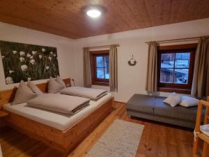 1 dormitorio con 2 camas, sofá y ventanas en Hinterauerhof, en Matrei in Osttirol