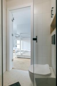 a bathroom with a toilet and a glass shower door at Maszop Kuźnica in Kuźnica