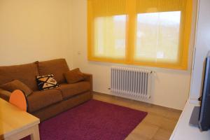 a living room with a couch and a window at Casa con jardín en Rascafría in Rascafría