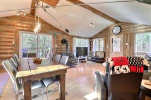 comedor y sala de estar con mesa y sillas en Chalet L'Ours charmeur du lac Sept-Îles en Saint-Raymond