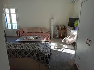 een slaapkamer met een bed, een tafel en een televisie bij Εξαιρετικό διαμέρισμα δίπλα στο λιμανι! Καινουριο in Naxos Chora