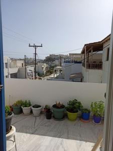 une rangée de plantes en pot assise sur un balcon dans l'établissement Εξαιρετικό διαμέρισμα δίπλα στο λιμανι! Καινουριο, à Naxos Chora