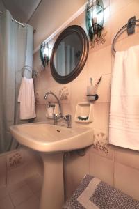y baño con lavabo, espejo y toallas. en Anna's House, en Áyios Kírikos