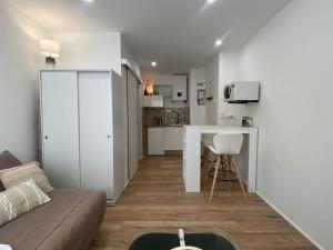 a living room with a couch and a kitchen at Mon petit studio à la mer in Gruissan