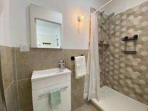 a bathroom with a sink and a shower at Mon petit studio à la mer in Gruissan