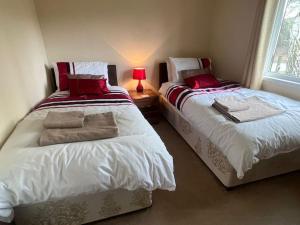 dwa łóżka siedzące obok siebie w sypialni w obiekcie Wentworth Gem w mieście Wisbech