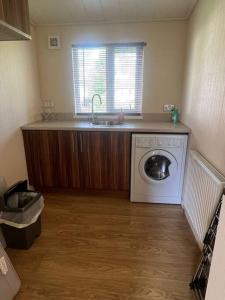 a kitchen with a sink and a washing machine at Wentworth Gem in Wisbech