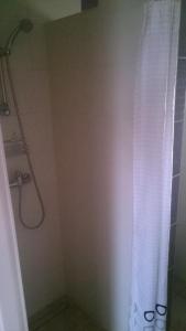 eine Dusche mit einem weißen Duschvorhang im Bad in der Unterkunft Pokoje gościnne Antonia in Władysławowo + 30 Fotos