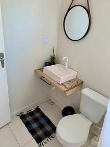 uma casa de banho com um WC branco e um lavatório. em Aconchego Penedo em Penedo