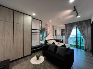 a living room with a black couch and a table at Vista Bangi Apartment in Kajang