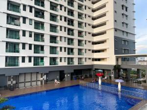 uma piscina de hotel em frente a um grande edifício em Vista Bangi Apartment em Kajang