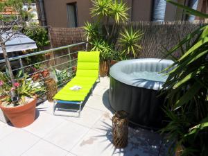 a hot tub and a chair on a patio at SETE BELLE MAISON DE VILLE 121 m2 A 2 mn DE LA PLAGE AVEC JACUZZI in Sète