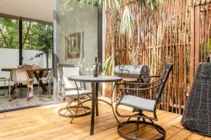 图卢姆Exclusive Villa "Town House" Luxury Amenities in Tulum的铺有木地板的庭院配有桌椅