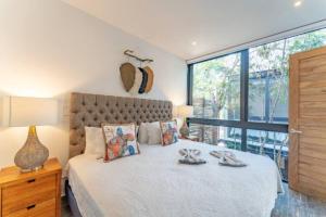 una camera da letto con un letto e una grande finestra di Exclusive Villa "Town House" Luxury Amenities in Tulum a Tulum