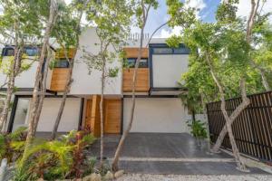 图卢姆Exclusive Villa "Town House" Luxury Amenities in Tulum的前面有树木的房子