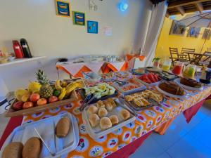 uma mesa com muitos tipos diferentes de alimentos sobre ele em Pousada Maravilha de Paraty em Paraty