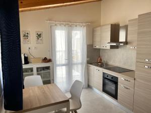 a kitchen with a table and a window and a stove at B&b AlgueRoof in Alghero