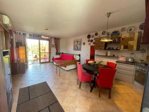 a kitchen and dining room with a table and red chairs at LunaSole Casa vacanza mare in Aprilia Marittima