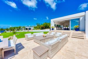 a patio with couches and a table and chairs at Villa El Grande Azure in Baie Longue
