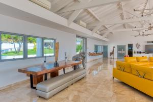 - un salon avec une table et un canapé jaune dans l'établissement Villa El Grande Azure, à Baie Longue
