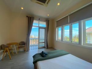 een slaapkamer met een bed en een groot raam bij Villa Sea Link - Phan Thiết in Phan Thiet