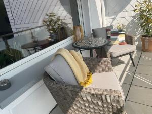 a balcony with a wicker chair and a table at Tarrazza Ferienwohnungen Erpeldinger in Ellenz-Poltersdorf